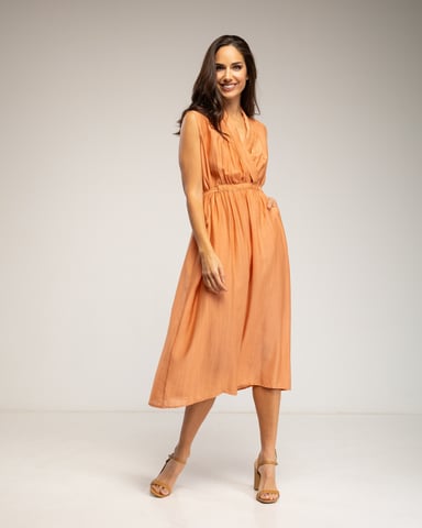 Sleeveless dress with crossover neckline, belt, and pockets