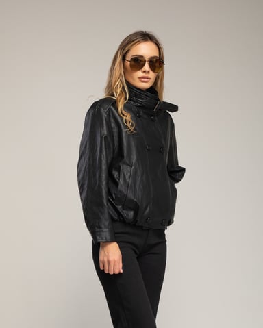 Wide faux leather jacket with double button closure, gathered at the waist, and neck closure with buckle