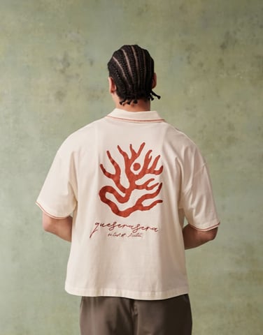 ASOS DESIGN boxig kortärmad polo med brodyr på bröstet och grafik på ryggen i off white