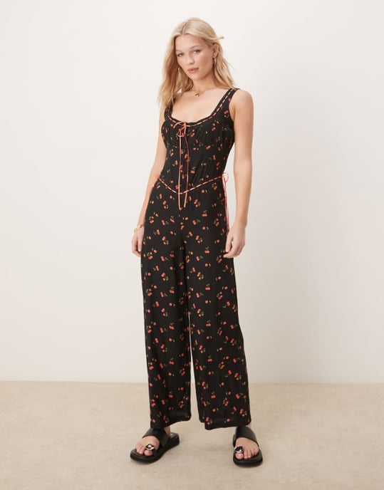 ASOS DESIGN jumpsuit med spetsdetaljer och knäppning framtill, vida ben, i svart körsbärsmönster - Image 1