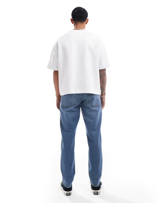 ASOS DESIGN tapered jeans med slitage i mellanmörk blå - Image 2