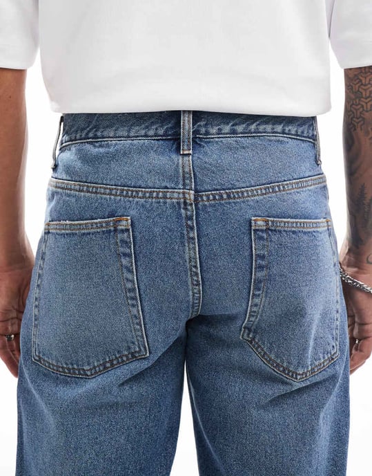 ASOS DESIGN tapered jeans med slitage i mellanmörk blå - Image 4