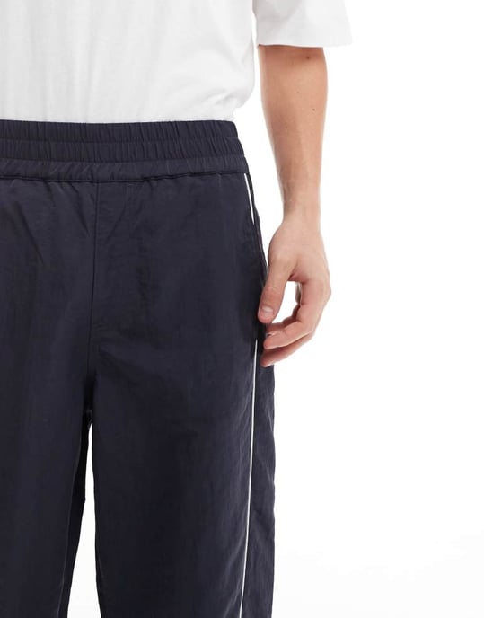 ASOS DESIGN baggy nylon träningsbyxor med vit kant i marinblått - Image 3