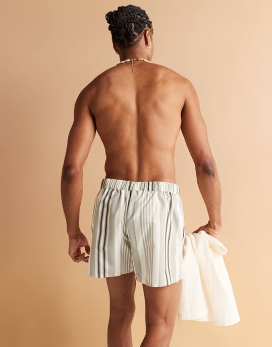 ASOS DESIGN swim shorts in short length in cream stripe with placement print - Image 1
