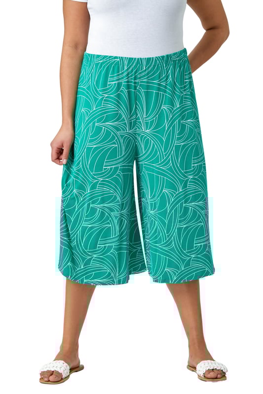Curve Abstract Swirl Stretch Cropped Culottes from Roman. Say hello to your new favourite staple piece in a bold abstract print. Roman Curve's new and stylish wide-leg culottes are everything you need. Soft stretchy jersey fabric and an elasticated waist make these floaty trousers comfortable and wearable throughout the season. Our casual pull-on bottoms are so versatile, wear with our matching top (19292234) for a striking daytime style.
