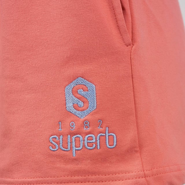 De #SuperbTotalLook waarmee je je op elk moment en in elke situatie jezelf kunt voelen. Een total look in pastelkleuren waarmee je je gelukkig kunt voelen en kunt genieten, zonder aan iets anders te denken, van de essentie van een felbegeerde zomer. Be Happy is de nieuwe Superb collectie voor elke dag, voor alle momenten. Be Happy is jezelf zijn, je vrij voelen.

 Kenmerken:

 Korte shorts met steekzakken
 Biezen in verschillende kleuren
 Schitterend geborduurd logo, voor een contrast van pastelkleuren
 Rubber in de taille
 Gemaakt en ontworpen in Barcelona door het Superb team
 Ons model Valeria is 1.69m lang en draagt maat S.

 Samenstelling:
 96% katoen
 4% elastaan
 Samenstelling: 96% katoen
 4% elastaan
 Onderhoud:
Wassen op maximum temperatuur 30º.
 Strijken op lage temperatuur.
 Je kunt een droger gebruiken.
 Geen bleekmiddel gebruiken.
