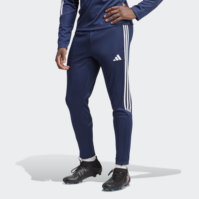 Essential training gear from adidas. Before you hit the pitch for that chilly winter session, layer up in these Tiro 23 Club football pants. Their slim, streamlined fit and moisture-absorbing AEROREADY will keep you flying through sprints and rondos. Once you reach perfect temperature, ankle zips make pulling them off over your boots a breeze.Made with 100% recycled materials, this product represents just one of adidas' solutions to help end plastic waste.  - Slim fit with mid rise - Elastic waist with drawcord - 100% polyester (recycled) - AEROREADY - Side zip pockets - Ankle zips  Shipped by adidas