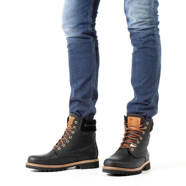 Steigen Sie mit Stil und Komfort aus mit Panama Jack-Stiefeln. Egal, ob Sie über schroffe Landwege wandern oder durch Stadtstraßen navigieren, der originale Panama Jack 03 C27 Herren-Schnürstiefel ist Ihr perfekter Begleiter. Im klassischen Design mit schlichter runder Spitze und schwarzem, gepolstertem Lederkragen strahlen diese Stiefel zeitlose Eleganz aus. Die kontrastierenden Schnürsenkel sorgen für einen Farbtupfer, während die genähte schwarze Commando-Sohle für Haltbarkeit und Stabilität in jedem Gelände sorgt. Für die Herren sind die schwarzen Panama Jack 03 Schnürstiefeletten für Herren so konzipiert, dass sie den Elementen standhalten. Mit einem wasserdichten, glatten Nubuk-Obermaterial, einem weich gepolsterten Knöchelschaft und einem warmen Futter halten diese Stiefel Ihre Füße kuschelig und trocken. Das geprägte Logo an der Ferse und die silbernen sechseckigen Metallösen verleihen ihrem robusten Charme einen Hauch von Raffinesse. Hauptmerkmale: Klassisches Design: Die Panama 03-Stiefel vereinen Design, Qualität und Komfort nahtlos und bieten eine zeitlose Ästhetik für Männer und Frauen. Vielseitiger Tragekomfort: Egal, ob Sie die Straßen der Stadt erkunden oder Bergpfade erobern, diese Stiefel sind perfekt für alle Ihre täglichen Abenteuer. Wasserdichte Konstruktion: Diese Stiefel sind aus wasserdichtem Vintage-Nappaleder mit Lederfutter gefertigt und sorgen dafür, dass Ihre Füße bei jedem Wetter trocken und bequem bleiben. Anatomische Unterstützung: Genießen Sie verbesserten Komfort und Hygiene mit der anatomisch geformten Innensohle, die eine perfekte Passform für Ihre Füße bietet. Langlebig und rutschfest: Die Gummiaußensohle bietet Flexibilität, Haltbarkeit und rutschfeste Traktion und sorgt für Stabilität auf verschiedenen Oberflächen. Hergestellt in Spanien: Mit einer Schafthöhe von 18 cm werden diese Stiefel fachmännisch in Spanien gefertigt, um höchste Handwerkskunst und Qualität zu gewährleisten. Schlüpfen Sie in die Stiefel von Panama Jack und erleben Sie die perfekte Mischung aus Stil, Haltbarkeit und Komfort für Ihre alltäglichen Abenteuer. Diese Stiefel wurden für alle entwickelt, die Wert auf Qualität und Handwerkskunst legen und sind Ihr vertrauenswürdiger Begleiter, wohin auch immer Ihre Reise Sie führt