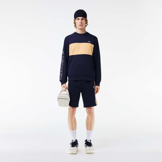 Color combination and graphics for a Lacoste dynamic and creative identity. Classic fit  natural ease on body with comfortable sleeves Our classic French terry Cut & sewn colorblock crew neck sweatshirt in mix of two different colors Rib at sleeves and bottom of body 3cm green crocodile at chest Lacoste wording 3D print at right sleeve.