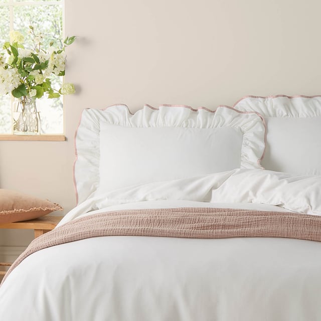 Transform your bedroom into a serene retreat with the Blousey Pillowcases. Crafted from 100% cotton sateen with a luxurious 180 thread count, these pillowcases are as soft as they are stylish. A subtle yet elegant ruffled trim, accentuated by a delicate piped detail, adds a touch of timeless sophistication to your bedding ensemble. Perfect for layering with textured throws or cushions, they create an effortlessly cosy yet refined aesthetic that complements both minimalist and relaxed interiors. These pillowcases not only enhance your bedroom’s visual appeal but also provide a breathable, comfortable surface for restful sleep.