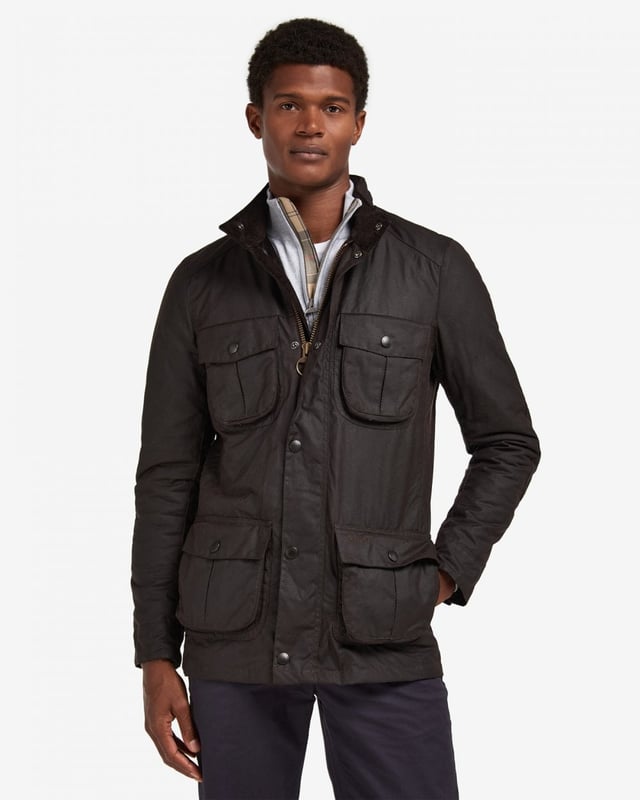 Barbour Corbridge Wax Jacket
The Corbridge is a rugged utility-style men's waxed jacket updated with a contemporary engineered fit. With winter in mind, this multi-functional jacket is constructed in Barbour's hardy 6oz Sylkoil waxed cotton with a comfortable, lightweight Nylon lining quilted to 50g wadding, for additional warmth. The corduroy-lined funnel collar features an integral Nylon hood complete with adjustable toggles for a perfect fit, offering wet-weather defence when needed but easily stowed away in the collar on dry days. Built to offer comfort and protection to those who are active outdoors in any weather, the Corbridge benefits from adjustable cuffs, a robust two-way zip, a storm fly front with stud fastenings and an action back. The classic four-pocket detail adds a stylish, practical feature that keeps essentials safe and hands free. Available in a choice of three versatile colours. As this is a slim fitting jacket, we would advise purchasing the next size up than you would normally choose.

Tailored Fit
Barbour tonal embroidery to left pocket
Outer: 100% cotton (waxed)
Inner: 100% polyamide
6oz waxed cotton
Do not wash
Sponge clean only
Back length: 78.8cm - 83cm

MWX0340