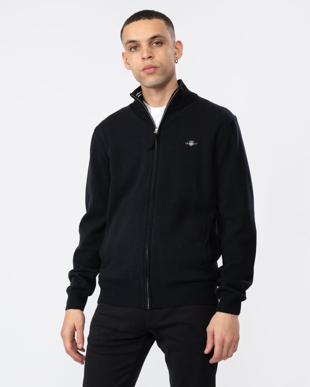 Your classic, wear-with-anything sweater. Crafted from 100% superfine lambswool, this cardigan with a zipped front is perfect for layering. Cut for a regular fit with ribbed detailing at the hem and cuffs.

Regular fit
Zip front
Rib endings at hem and sleeve cuffs
GANT graphic embroidered at chest

Material: Lambswool 100%
87214
 
 