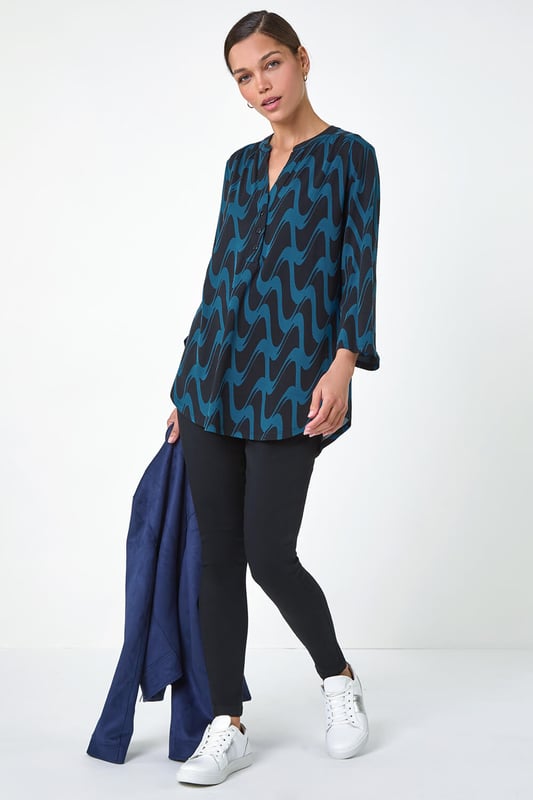 Geometric Print Stretch Blouse from Roman. Elevate your wardrobe this season with our stunning abstract blouse. The bold print and woven silhouette make it versatile for any occasion. The notch neckline, adjustable 3/4 length sleeves and front button details adds a touch of sophistication. Pair it with black jeans and boots for a daytime look or add tailored trousers perfect for those desk-to-dinner days
