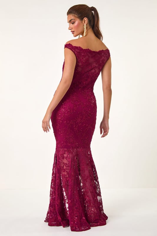 Lace Scallop Edge Front Split Maxi Dress from Roman. Get ready to make a statement in our stunning lace maxi dress. The feminine bardot neckline is adorned with delicate scalloped lace details, adding a touch of elegance to the look. Crafted from a stretch woven fabric, this bodycon dress hugs your shape beautifully and finishes at a flattering maxi length with a mermaid edge and front split for added drama. Pair with heels and a bolero for an unforgettable look!