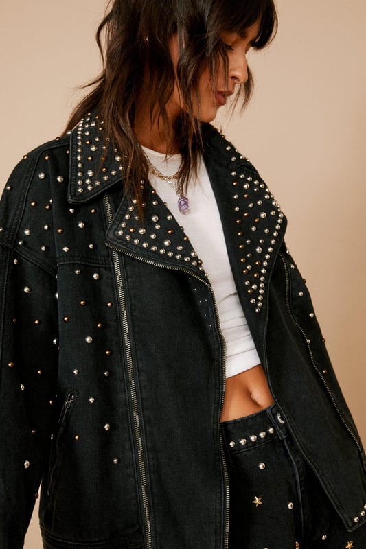 Edgy outer layers. Feel fierce in our denim jacket, made in high quality denim fabric, with a comfortable relaxed fit, and statement metallic stud detailing. Pairs well with a crop top, shorts, and boots for a look that will take you from festival weekends, to summer days out, to casual nights out. Premium Embellished Studded Denim Biker Jacket High Quality Denim Fabric Head Turning Stud Detailing Comfortable Relxed Fit Contrasting Metal Details Zip Front Fastening Model wears a size M (US size 6/UK size 10).