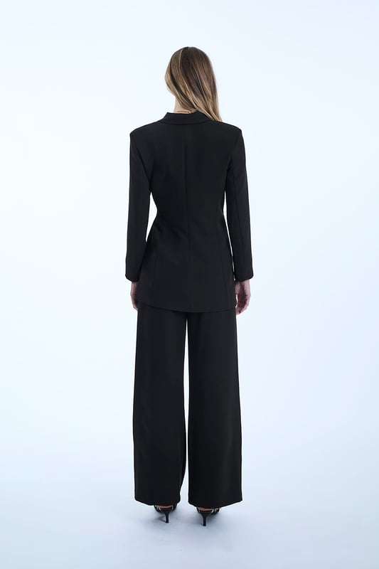 Chic James Lakeland Blazer with a shawl lapel and glamorous front ruching. Features a hidden front button and long sash belts for tying. Curved hems create a cinched waist illusion. Three-quarter sleeves and slim silhouette tailoring make this a sleek, stylish piece.