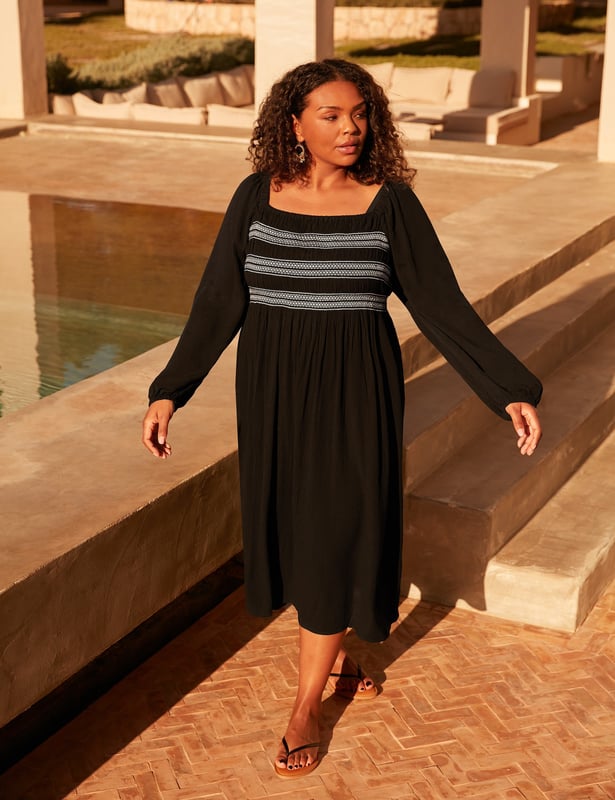 In classic black, this dress is cut from a soft, textured fabric thats so comfortable to wear. With elasticated shirring through the bodice in contrasting white, it has a flattering square-neck shape. Elastication around the neck and shoulder heads ensures comfort, while a cross-shoulder tie prevents the full-length sleeves from falling down. It has a stylish midaxi shape with a flowy skirt, making this the perfect warm weather piece.