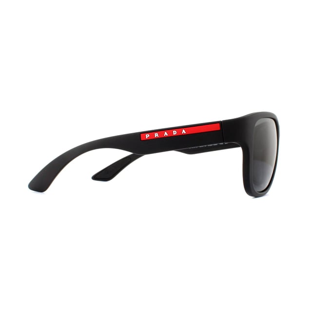 Prada Sport Sunglasses PS01US DG05S0 Black Rubber Grey are an easy to wear rectangular style. The bold style features thick temples with the red Prada Sport logo. A rubberised finish gives a sporty feel and the rubber inserts on the insides of the temples help to hold the sunglasses in place..