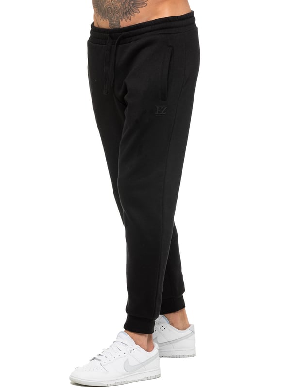 Enzo Mens Regular Fit Joggers. Elasticated Waistband With Adjustable Drawstring. Features 2 Side Slash Pockets & Single Welt Back Pocket. Cuffed Ankle. Features EZ Logo.