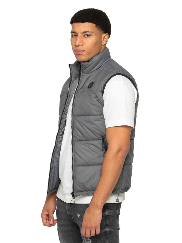 Embodying both fashion and function, the Enzo Mens Puffer Gilet boasts a water-resistant design and a high neck for added warmth. It also offers secure storage with zipped side pockets, and a custom fit with its elasticated hem and adjustable toggle. The full zip-up front and lined interior provide ultimate comfort and practicality. With a EZ branded badge on the chest, this gilet is crafted from durable 100% polyester and is conveniently machine washable.