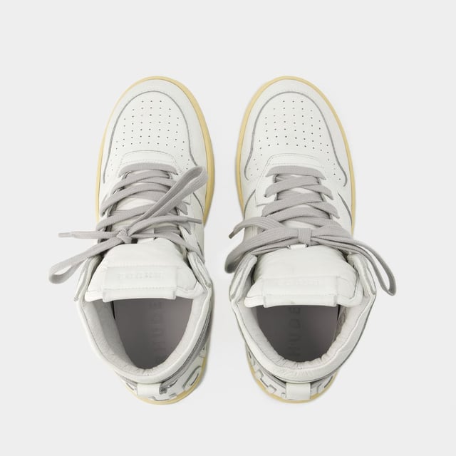 Presentamos las zapatillas Rhecess de Rhude, donde la frescura urbana se une a la comodidad contemporánea. Estas zapatillas fusionan a la perfección un diseño moderno con un guiño al estilo streetwear, mostrando una silueta única perfecta para ir a la moda statement. Para elevar tu look con estas zapatillas statement, considéralas la base de un conjunto moderno de inspiración callejera. Combínalas con unos vaqueros desgastados, una sudadera con capucha de estampado gráfico y unas gafas de sol atrevidas para conseguir un look vanguardista sin esfuerzo, perfecto para un día con amigos o una noche informal en la ciudad. Rhude Las zapatillas Rhecess de brand ejemplifican el compromiso de la marca con la calidad y la moda, ofreciéndote una opción de calzado distintiva y versátil que combina sin esfuerzo el encanto moderno con el estilo urbano. Sal con confianza, mostrando tu sensibilidad única por la moda y tu estilo de entrenador contemporáneo. Colores: Blanco - Blanco/Blanco. Material principal: piel de ternero lisa. Material de la suela: caucho. Material del forro: algodón. Cierre: cordones en la parte superior. Forma de la punta: almendra. Ajuste: fiel a la talla - Talla: