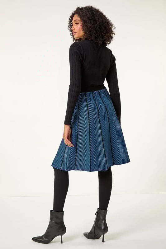 Chevron Print Belted Jumper Dress from Roman. Upgrade your daytime wardrobe with this elegant knee-length, knitted dress. Cut from a soft knitted fabric this dress features a modest round neckline and cosy full-length sleeves. A printed, panelled contrast skirt falls to a fun knee-length in a flattering fit and flare style. A self-tie fabric belt adds shape at the waist if desired while its pull-on style makes for quick and easy dressing. Pair with tights, boots and a fluffy gilet for a cute and casual everyday style!