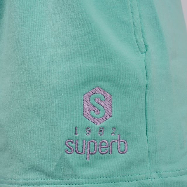 De #SuperbTotalLook waarmee je je op elk moment en in elke situatie jezelf kunt voelen. Een total look in pastelkleuren waarmee je je gelukkig kunt voelen en kunt genieten, zonder aan iets anders te denken, van de essentie van een felbegeerde zomer. Be Happy is de nieuwe Superb collectie voor elke dag, voor alle momenten. Be Happy is jezelf zijn, je vrij voelen.

 Kenmerken:

 Korte shorts met steekzakken
 Biezen in verschillende kleuren
 Schitterend geborduurd logo, voor een contrast van pastelkleuren
 Rubber in de taille
 Gemaakt en ontworpen in Barcelona door het Superb team
 Ons model Valeria is 1.69m lang en draagt maat S.

 Samenstelling:
 96% katoen
 4% elastaan
 Samenstelling: 96% katoen
 4% elastaan
 Onderhoud:
Wassen op maximum temperatuur 30º.
 Strijken op lage temperatuur.
 Je kunt een droger gebruiken.
 Geen bleekmiddel gebruiken.