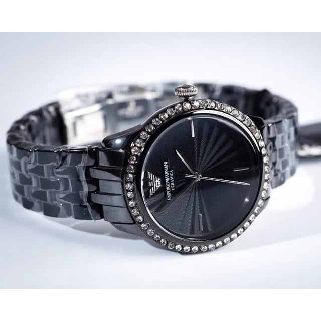 Japanese Made Quartz Automatic Movement. 36mm x 11mm Black Polished Ceramic Case. Solid Stainless Steel Caseback. Bezel Set with Gems. Push-Pull Crown. Black Sunray Dial. Polished Stainless Steel Hands and Indexes. 15mm Width Black Ceramic Bracelet with Hidden Deployment Clasp. Water Resistant to 30 Meters 3ATM. This watch is and comes with the Box and Paperwork.