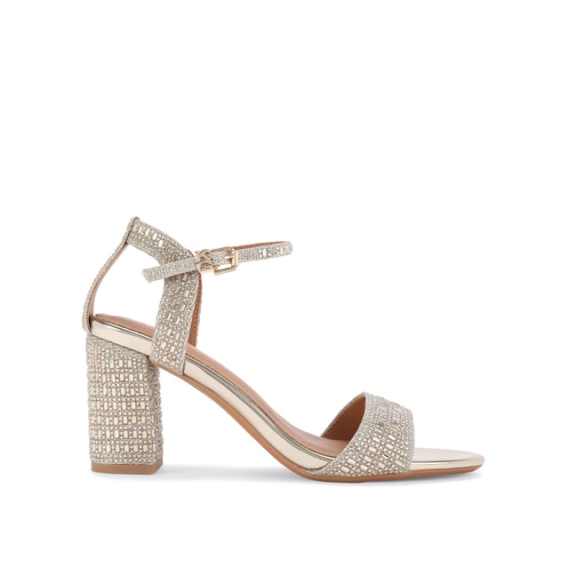 The KG Kurt Geiger Fleur bling block heel features a gold fabric upper embellished with silver crystals. The ankle strap is fastened with a gold buckle with KG Kurt Geiger tab. Heel height: 7.5cm.