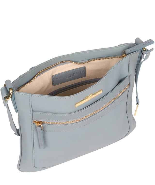 The 'Lewes' cross body bag from Pure Luxuries London, is crafted from naturally milled leather with a beautifully distinct fine-grain feel. A zip-over top secures a gorgeous, 100% natural cotton-lined interior with two slip pockets. On-the-go storage comes in the form of an exterior zipped pocket and two slip pockets, complemented by an adjustable and matching leather shoulder strap. Furnished with gold coloured metal fittings and the elegant Pure Luxuries London charm and logo plate.