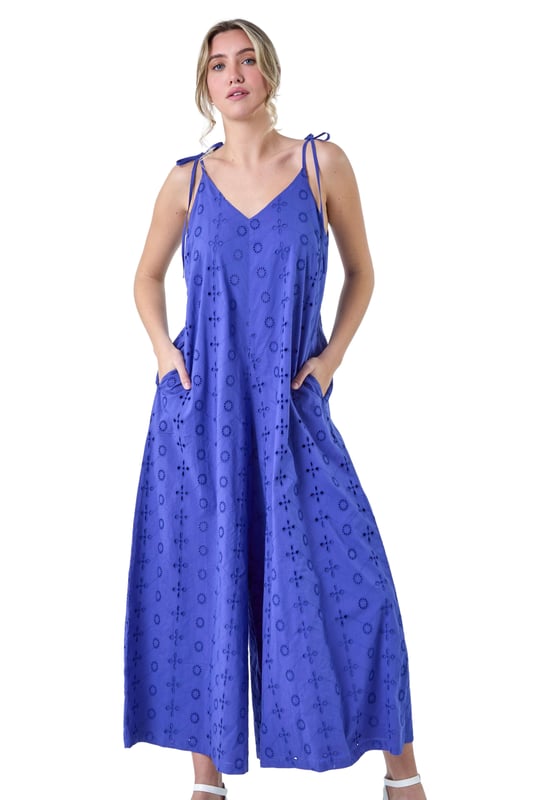Cotton Broderie Pocket Wide Leg Jumpsuit from Roman. Perfect for Summer, our new Dusk jumpsuit is destined for your holiday wardrobe. Created with tie detail straps and a flattering v-neckline, it is crafted from a cool cotton broderie fabric with embroidery detail throughout. The floaty wide leg silhouette is ideal for the warmer weather, topped off with handy side pockets for your everyday essentials. Pair with sandals and a denim jacket for a relaxed look!
