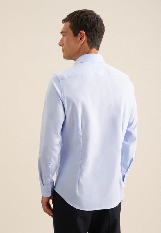 Maskuline Ästhetik: Das blickdichte Business Hemd von Seidensticker aus der "SMART CLASSICS" Kollektion erweitert Ihre Garderobe um einen hochwertigen Look, der den Geist der Zeit trifft. Es ist ein vielseitiger Begleiter, der sich ideal für Büro, Homeoffice oder Veranstaltungen eignet und überall überzeugt. Twill wird besonders hochwertig gewebt. In Kombination mit 100% Baumwolle ist es bequem zu tragen und mit schräg umlaufender Struktur sehr griffig. Die schmale Silhouette dieses Business Hemds in der Passform Shaped betont Ihre Figur ohne dabei zu eng anzuliegen. Dieses Hemd verkörpert zeitlose Eleganz mit modernem Schliff. Stilsicher und elegant liegen Sie mit diesem Langarm-Business Hemd stets richtig. Weitenverstellbare Manschetten ergänzen das klassische Gesamtbild. Hervorragend unterstrichen wird der universelle Business-Charakter durch einen Kentkragen.
