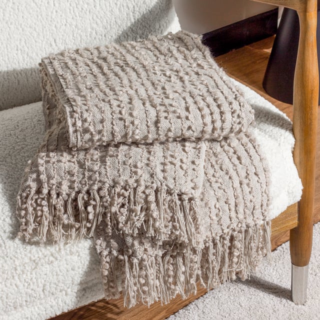 Add instant style and texture to any space with the Arvo throw. This woven design is adorned with elegant strands of vertical boucle yarn, which slide gracefully down the piece, until they meet the textural fringing at both ends. It comes in a range of muted, chic tones, which are inspired by modern neutrals and fashion fabrics. A simple, but polished throw to drape on your sofa or bed to add instant style and texture to your home.