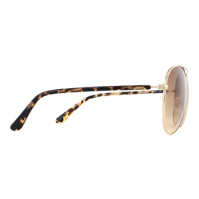 Calvin Klein Sunglasses CK19314S 717 Gold Tortoise Brown Gradient are a typical aviator style with large teardrop shaped lenses. A metal frame front features adjustable nose pads, and plastic temples showcase the Calvin Klein logo.