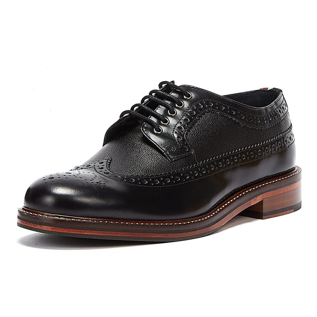 Ben Sherman Archie Brogue Herren Schwarz Schuhe Ein raffinierter Schuhstil, der perfekt ist, wenn Turnschuhe einfach nicht ausreichen. Diese Brogues von Ben Sherman verfügen über ein hochwertiges Obermaterial aus Leder mit dekorativen Perforationen und einer traditionellen Brogue-Konstruktion mit Flügelspitze. Gesichert mit einem 5-Augen-Schnürverschluss und mit einer klassischen gestapelten Sohle mit Gummieinsatz abgeschlossen.