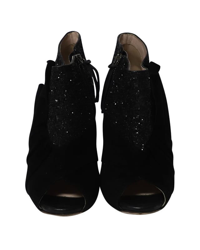 VINTAGE, UVP WIE NEU  
Diese schwarzen Peep-Toe-Stiefeletten von Miu Miu sind aus Wildleder gefertigt und mit Glitter überzogen, um deinen Stil gezielt zu heben. Sie sind mit Reißverschlüssen, Leder-Innensohlen ausgestattet und der Absatz misst 115 mm. Der Wildlederbereich der Schuhe ist so gestaltet, dass er wie ein Band aussieht, was einen zusätzlichen femininen Akzent setzt.

Miu Miu 115mm Glitter-Stiefeletten aus schwarzem Wildleder  
Zustand: Gut  
Nutzungsspuren: Starke Abnutzung an den Sohlen  
Material: Wildleder/Leder  
Größe: 38.5/US8.5  
Absatzhöhe: 115 cm  
SKU: 124358
