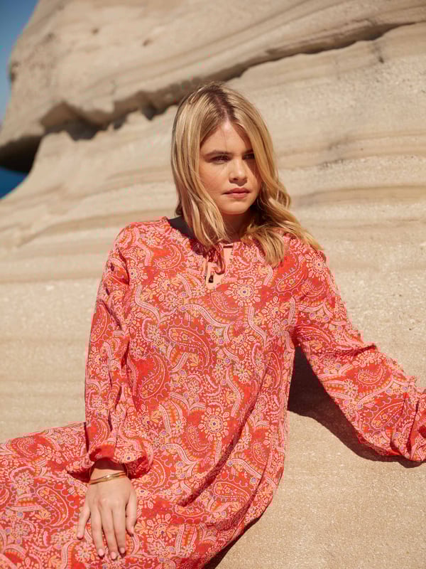 Printed all over with a pretty red paisley print, this dress is cut from a soft woven fabric that moves beautifully. It has a V-neckline with fixed tie detailing, as well as full-length raglan sleeves with elasticated cuffs. Its maxi length makes it the perfect throw-on piece, ideal for any holiday or summer look.