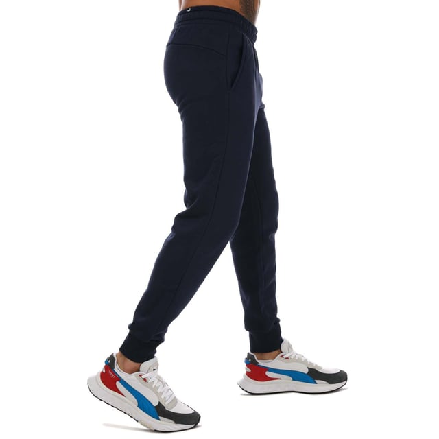 Mens Puma Essentials Logo Sweatpants in navy.- Elasticated waist with inner drawcord.- Two front pockets.- Ribbed ankle cuffs.- Printed branding.- Brushback fleece.- Regular fit.- Shell: 66% Cotton  34% Elastane. Rib: 97% Cotton  3% Elastane.- Ref: 58671476