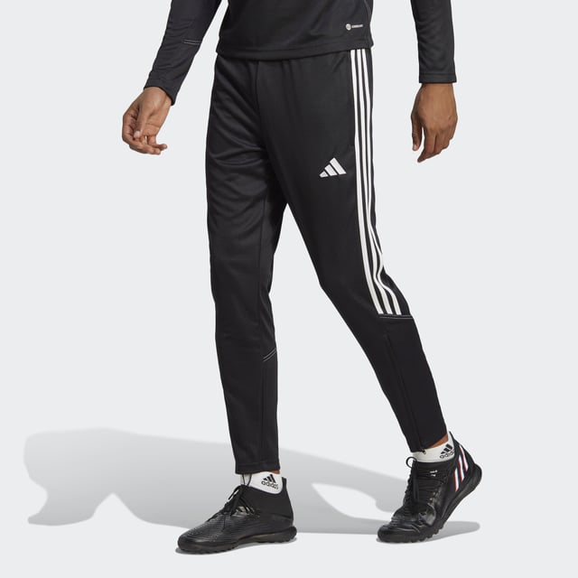 Essential training gear from adidas. Before you hit the pitch for that chilly winter session, layer up in these Tiro 23 Club football pants. Their slim, streamlined fit and moisture-absorbing AEROREADY will keep you flying through sprints and rondos. Once you reach perfect temperature, ankle zips make pulling them off over your boots a breeze.Made with 100% recycled materials, this product represents just one of adidas' solutions to help end plastic waste.  - This model is 184 cm and wears a size M. Their chest measures 101 cm and the waist 63 cm. - Slim fit with mid rise - Elastic waist with drawcord - 100% recycled polyester doubleknit - AEROREADY - Side zip pockets - Ankle zips  Shipped by adidas