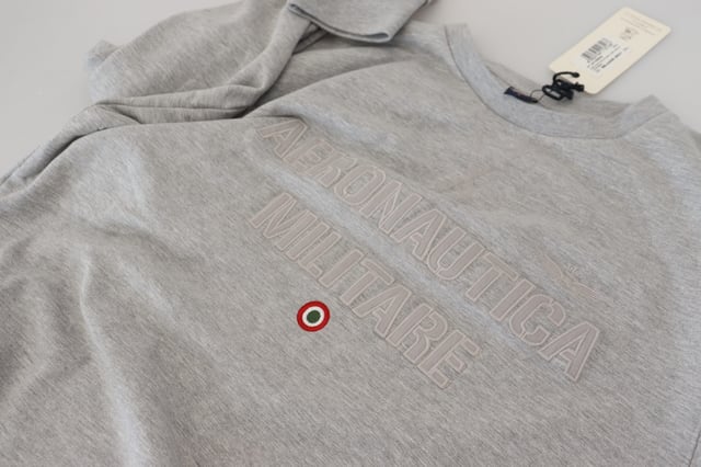 Merk: AERONAUTICA MILITARE  
Staat: Helemaal nieuw met labels  
Stijl: Pullovertrui  
Kleur: Grijs  
Logo-details  
Gemaakt in Italië  
Materiaal: 62% Katoen 32% Polyester 6% Elastaan  
Geslacht: Heren  
Materiaal: 62% Katoen 32% Polyester 6% Elastaan