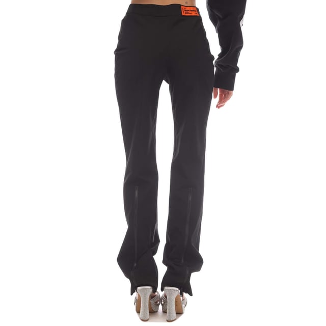 Womens Heron Preston Garbardine Stretch Zip Pants in black.- Elasticated waistband.- Pockets at side.- Orange logo patch sewn at waist on the back.- Zip fastening at front legs.- Stretch.- 66% Polyester  28% Viscose  6% Elastane.- Ref: HWCA028S211000