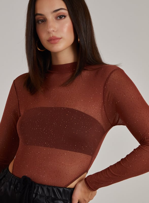 Make a statement this season with this Glitter Long Sleeve Bodysuit. Add this to any outfit for an insta-worthy 'fit. Pair with flares and strappy heels for an easy, chic style.