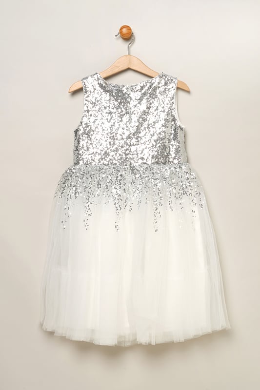 Step into magic with this sequin waterfall dress from Luna Moon by Miss, featuring a stunning large bow at the back. Watch her dazzle in this mesmerizing ensemble, effortlessly transitioning from shimmering sequins to a flowing tulle skirt. Perfect for special occasions, this dress promises to charm wherever she goes. This dress is the perfect blend of sparkle and sophistication.