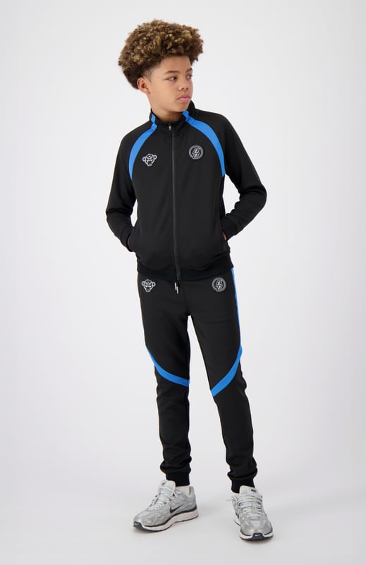 100 % Polyester Normale Passform Zwei Markenpatches auf der Vorderseite Zwei Fronttaschen Mit sportlichen Streifen verziert Kombinierbar mit JR. COMPOUND TRACKTOP 