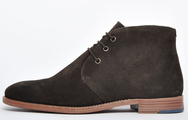 A signature style from Catesby England, this Austell Chukka desert style boot is crafted from a premium suede leather and is a timeless, reliable mid cut boot that will go with any outfit to complete that smart casual look.
 This premium mens boot with its high-end suede leather upper and durable grippy rubber sole, is finished with intricate designer stitch detail throughout providing on-trend wear wherever you go. Stitch work and panelling throughout add originality making the Catesby England desert boot a stand-out from the crowd model. A slim line durable outsole completes the on trend look making the Catesby England a boot perfect for work, or to enhance your casual everyday outfit with a bit of formality this season.
 - Premium suede leather upper
 - 3 Eyelet lace up fastening
 - Comfortable inner lining
 - Intricate designer stitch detailing
 - Additional laces included to change your look
 - Durable rubber outsole