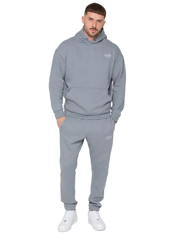 Presentamos el Conjunto de Chándal con Sudadera con Capucha Oversized Averè para Hombre de Enzo Milano, una mezcla perfecta de comodidad y estilo. Este set incluye una Sudadera con Capucha Oversized con un suave forro de felpa, un logotipo sutil en el pecho, un diseño audaz en la parte trasera y una capucha con botones a presión. Los Joggers de Corte Regular tienen una cintura elástica, cordones ajustables, bolsillos laterales y puños acanalados en los tobillos para un ajuste seguro. Ideal para relajarse o para salidas casuales, este chándal ofrece un estilo relajado y a la moda