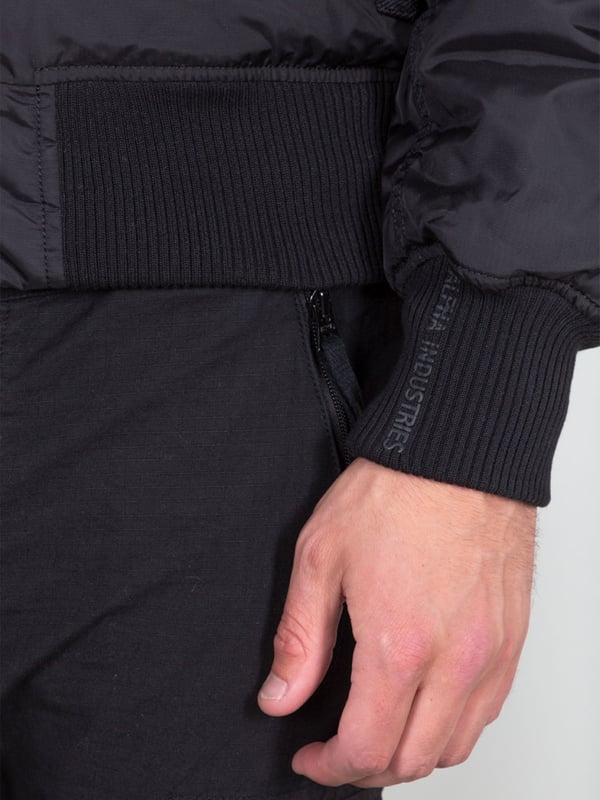Moderne Bomberjacke mit abnehmbarem Pelzkapuze, gepolstertem Futter und Flugnylon-Außenmaterial. Kontrastnähte; Kragen aus Schafsleder; RBF-Tag; Druck auf dem Ärmel; Bedruckte Manschette. Produktnummer: 143104-03 SCHWARZ