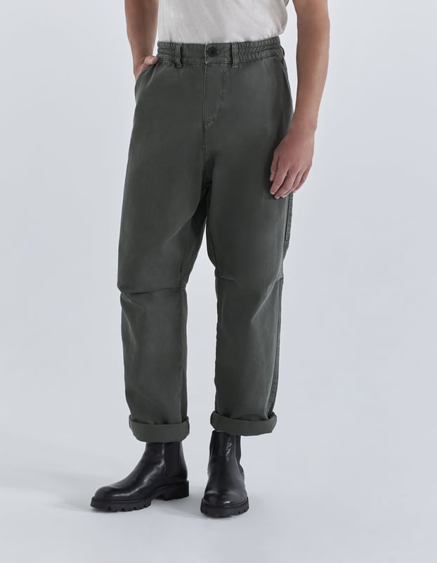 This cropped trousers has an elastic waist, zip and buttons fastening and pockets.