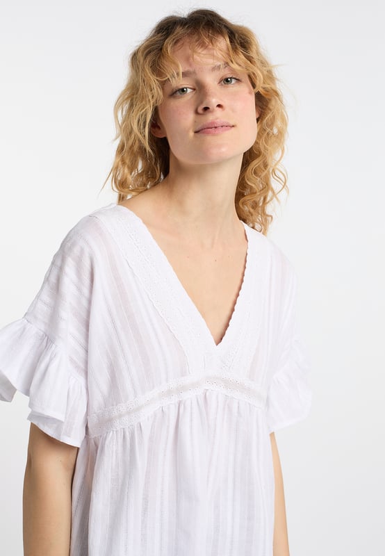 Diese leichte Baumwoll-Bluse von DreiMaster Vintage punktet mit ihrer zauberhaften Lochstickerei und dem gemusterten, fein strukturierten Baumwollstoff. Die lockerere Silhouette hat einen tiefen V-Ausschnitt auf der Vorder- und auf der Rückseite, wo er mit einem Spitzenband zusammengehalten wird. Die romantischen Rüschenärmel optimieren den femininen Boho-Look. Mit ihrer leichten Textur passt sie hervorragend zu Jeans und Röcken.  Tunika