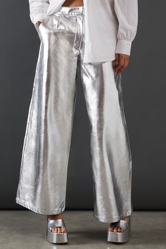 Eye-catching metallic finish for a bold statement
        Wide leg silhouette for a comfortable and trendy fit
        High-waisted design accentuates the waistline
        Front zip and button fastening for a secure fit
        Versatile style suitable for various occasions
    
    Make a dazzling entrance with these striking metallic wide leg jeans from Warehouse. Perfect for those who dare to stand out, these trousers combine comfort with high-impact style. The wide leg cut offers freedom of movement while creating a fashionable silhouette. For a night out on the town, pair these show-stopping trousers with a crisp white shirt, leaving it partially unbuttoned for a relaxed yet chic look. Add some platform sandals to elongate your legs and complete the ensemble with statement earrings. Whether you're hitting the dance floor or enjoying drinks with friends, these jeans will ensure you're the centre of attention. Their versatility also allows for more casual styling - try pairing with a simple black tee and trainers for an effortlessly cool daytime look that transitions seamlessly into evening wear.